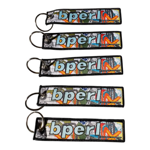 Woven fabric keychain with metal ring featuring colorful double-sided design and embroidered 'bperl' logo in bold lettering, shown in multiple angles.